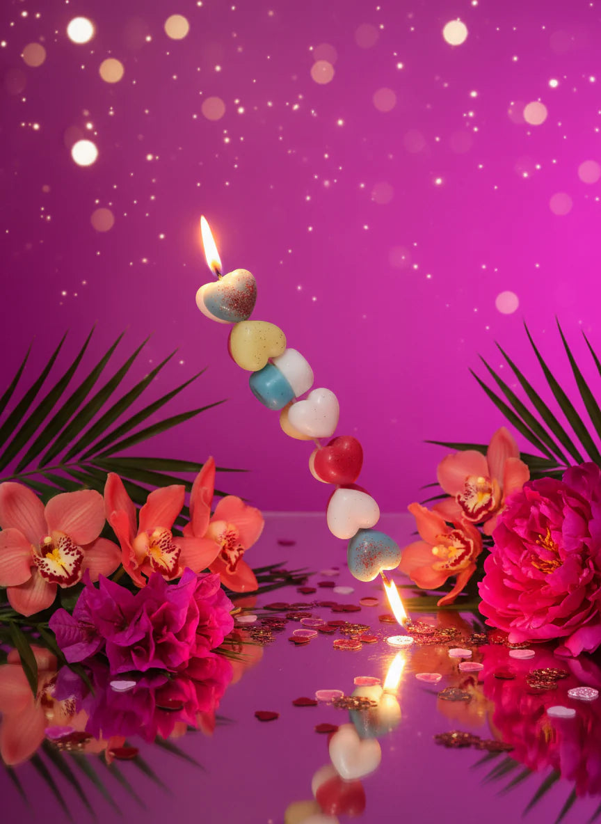 Colorful row of heart-shaped candles with flowers and a party purple theme